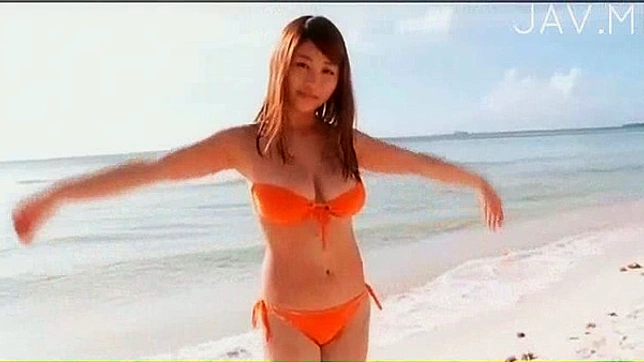 オレンジ色のビキニを着たセクシーな美女が、ビーチでセクシーなアソコを披露している。