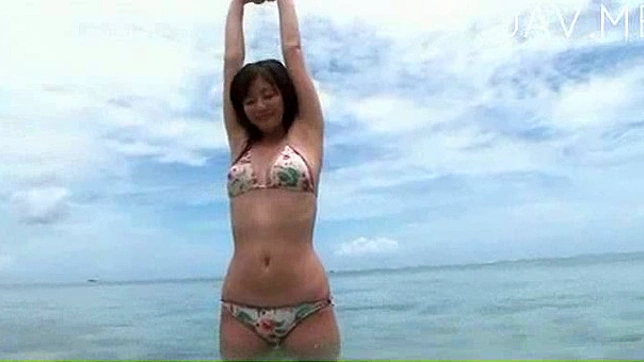 ビキニ姿のハンサムな日本人女性がビーチで休憩している。