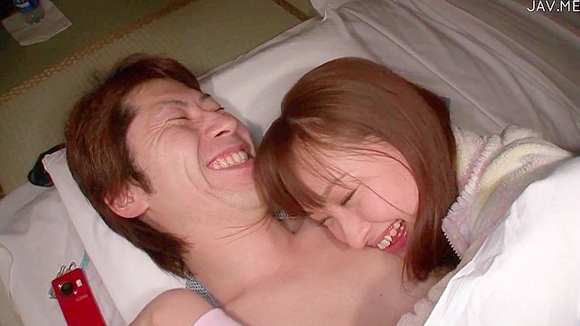 赤毛の幸せそうな日本人の女の子が、部屋でボーイフレンドとキスをしている。