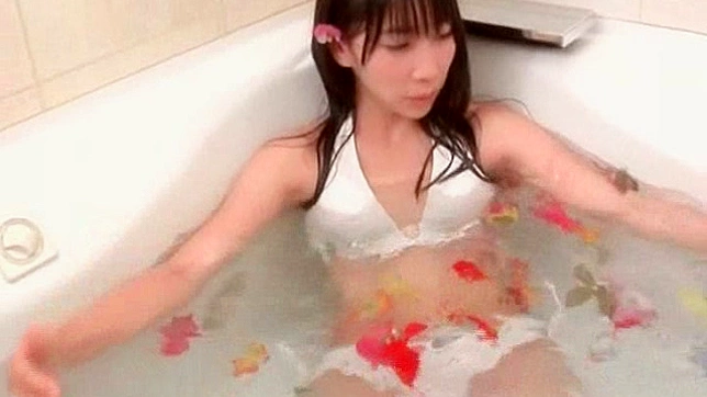 完璧な体型の魅力的なアジア人ポルノ女優が風呂でポーズをとっている。