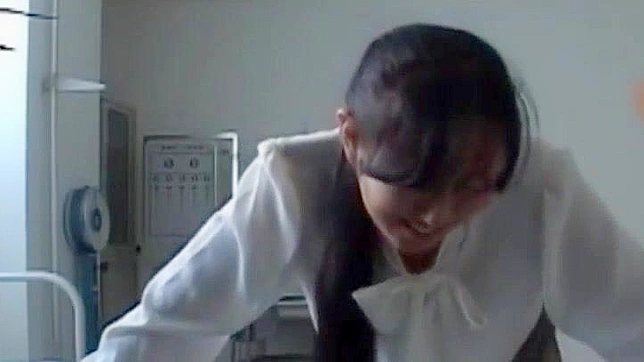 日本の女子生徒が放課後の居残りで厳しい教師にお尻を叩かれる