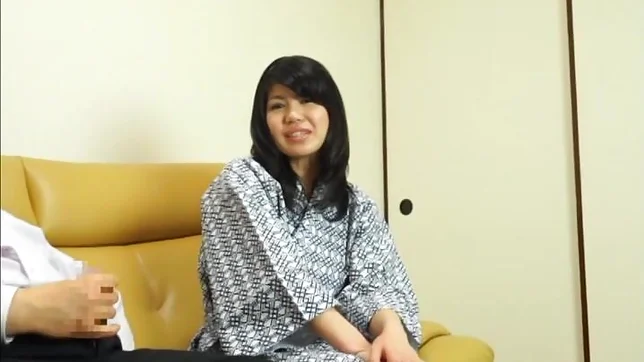 Hot Asian babe gives a nice handjob on a sofa