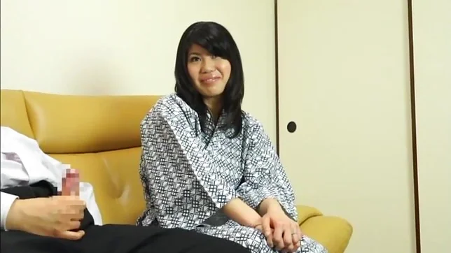 Hot Asian babe gives a nice handjob on a sofa